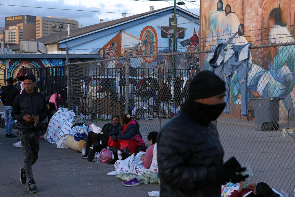 Migrants gather near Sacred Heart Church on Thursday.