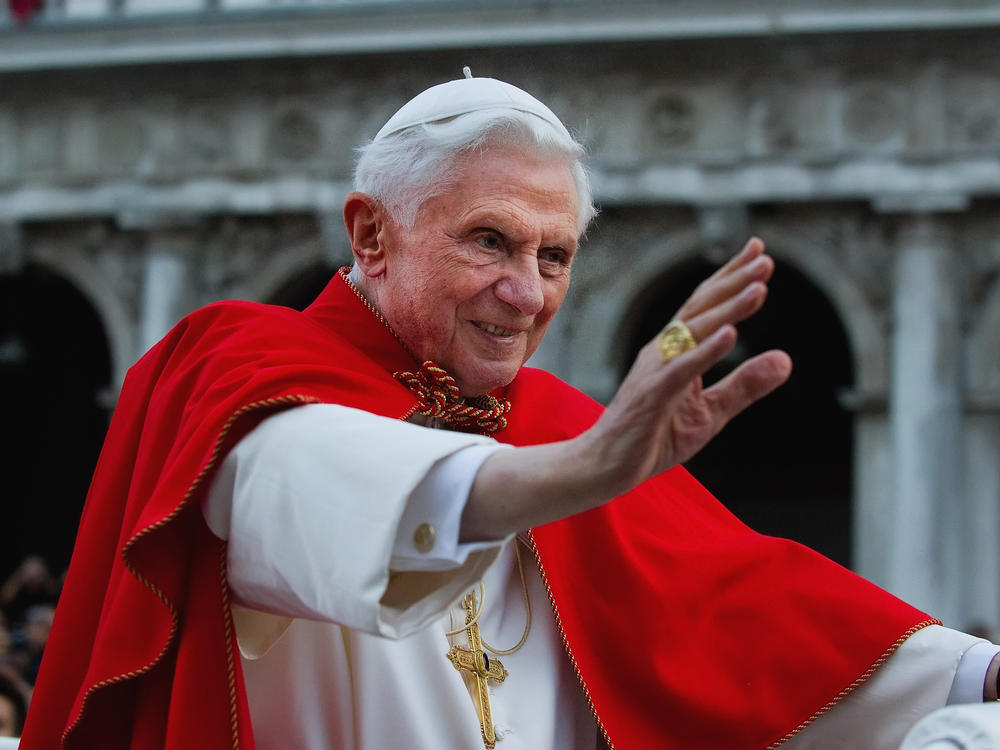 Pope Benedict XVI greets the crowd gathered in St Mark's Square while crossing the square on an electric car in 2011 in Venice, Italy.