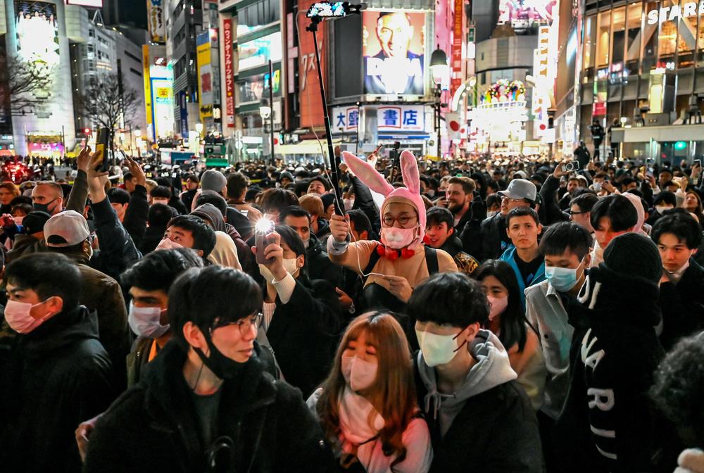 People try to cross the street shortly before midnight for New Year's celebrations in the Shibuya area of Tokyo.