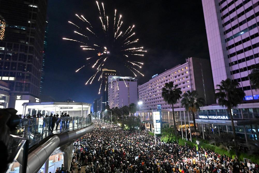 Revelers celebrate the New Year at the Selamat Datang Monument at the Hotel Indonesia roundabout in Jakarta, Indonesia.