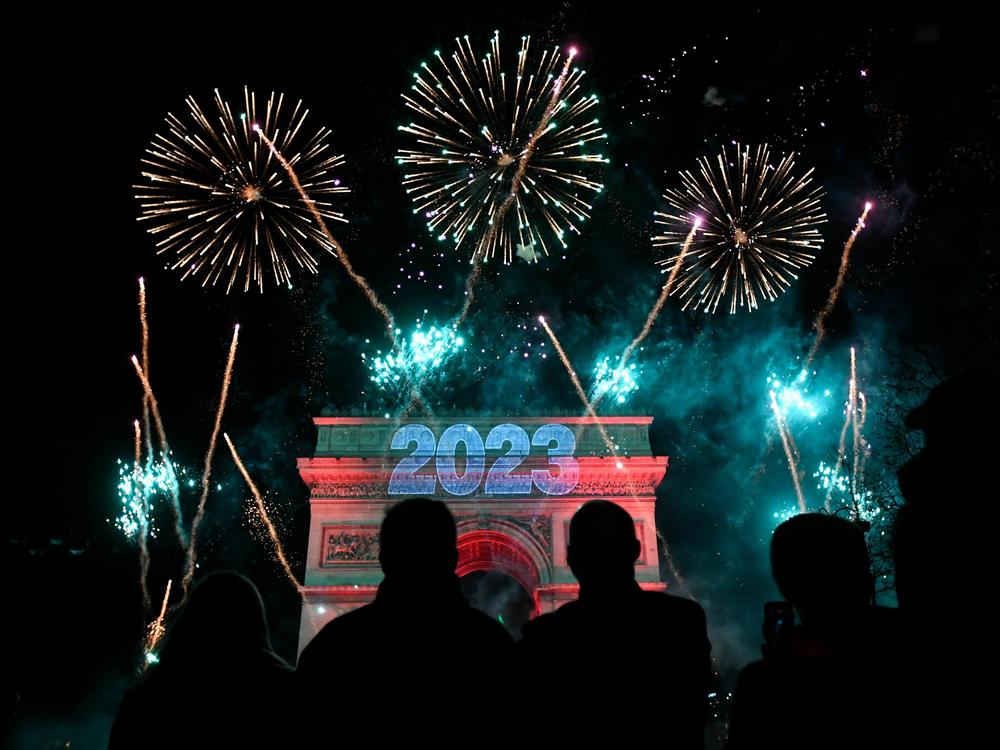 Fireworks explode next to the Arc de Triomphe with 