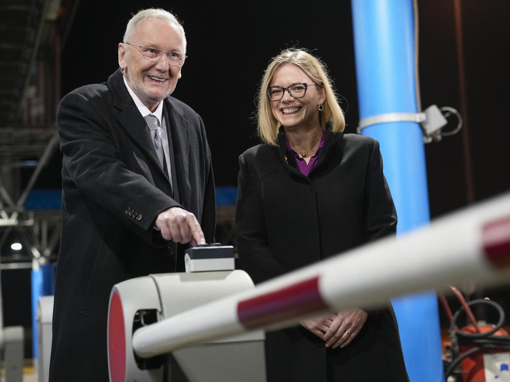 Croatia's Minister of Interior Davor Bozinovic, left, pushes a button to lift the barrier at the Bregana border crossing between Croatia and Slovenia, accompnanied by Slovenian counterpart Sanja Ajanovic Hovnik, early on Sunday.