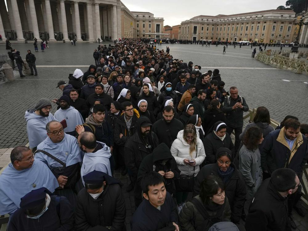 People wait in a line to enter Saint Peter's Basilica at the Vatican where late pope Benedict 16 is being laid in state at The Vatican, Monday, Jan. 2, 2023.