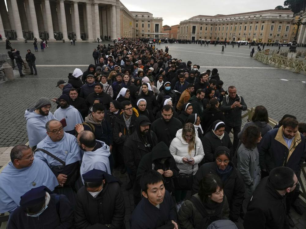 People wait in a line to enter Saint Peter's Basilica at the Vatican where late pope Benedict 16 is being laid in state at The Vatican, Monday, Jan. 2, 2023.