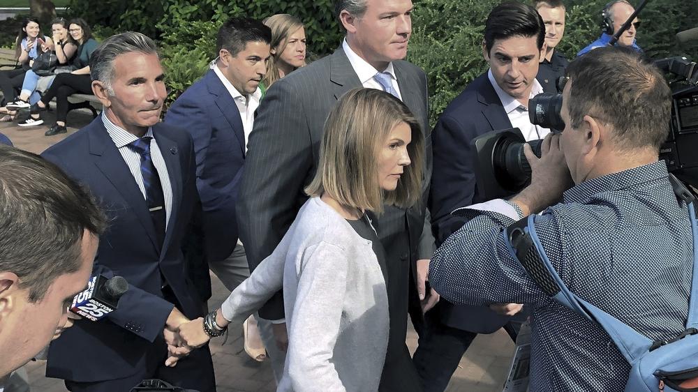 Actress Lori Loughlin leaves federal court in Boston with her husband, clothing designer Mossimo Giannulli (left) in Boston, after a 2019 hearing in the 