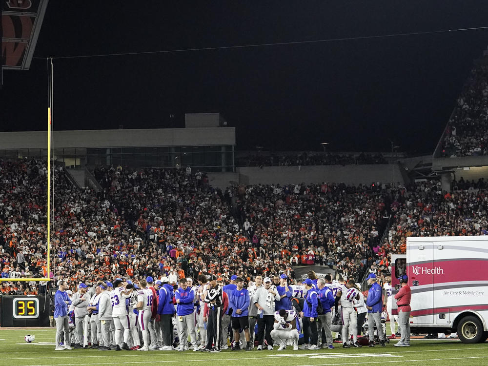Buffalo Bills players pray for teammate Damar Hamlin after he collapsed during the first half of their NFL game against the Cincinnati Bengals Monday night. The game has been postponed indefinitely, NFL Commissioner Roger Goodell announced.