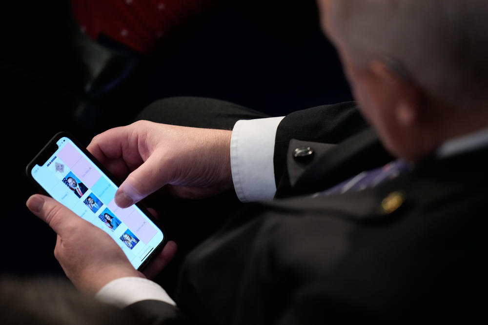 A member of Congress looks at photos of members on their mobile device during opening day of the 118th Congress at the U.S. Capitol on Jan 3. in Washington.