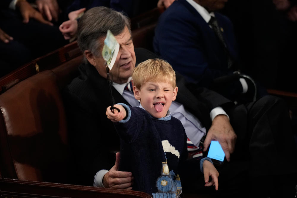 A child sits on the lap of Rep. Dutch Ruppersberger, D-Md., during opening day of the 118th Congress at the U.S. Capitol on Tuesday.