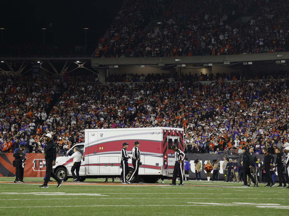 Fans watch as Buffalo Bills football player Damar Hamlin leaves Cincinnati's Paycor Stadium in an ambulance on Monday night after experiencing a cardiac arrest during a game.