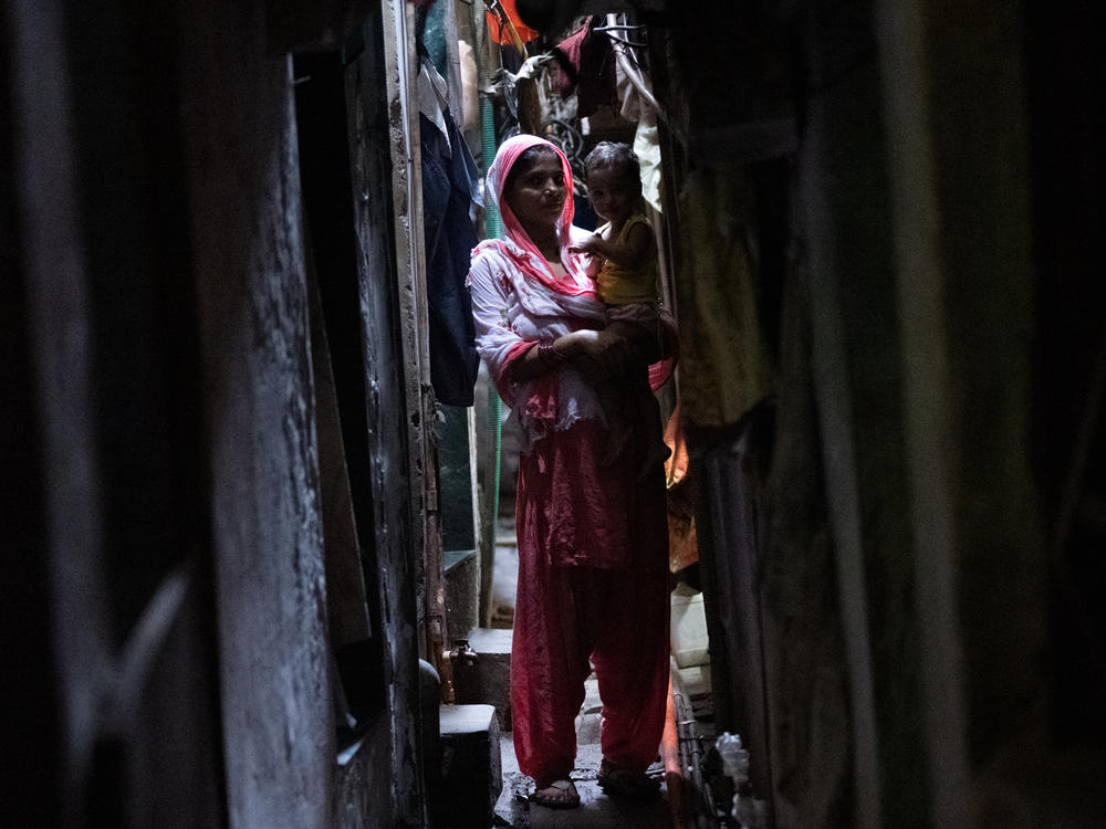 Shabana Khatoon, 23, holds her 9-month-old daughter, Adeeba, in one of the narrow alleyways in Dharavi, Mumbai — Asia's largest slum.