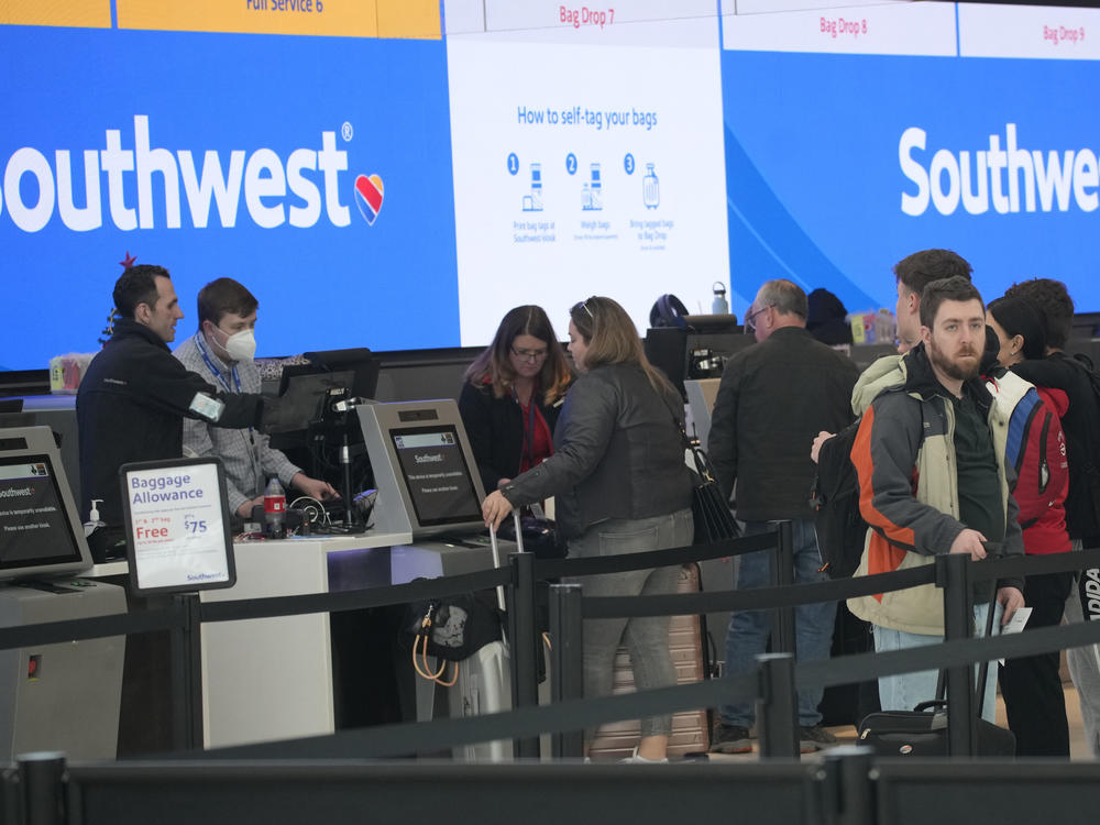 Travelers are shown lining up at the check-in counters for Southwest Airlines in Denver International Airport, Friday, Dec. 30, 2022, in Denver.