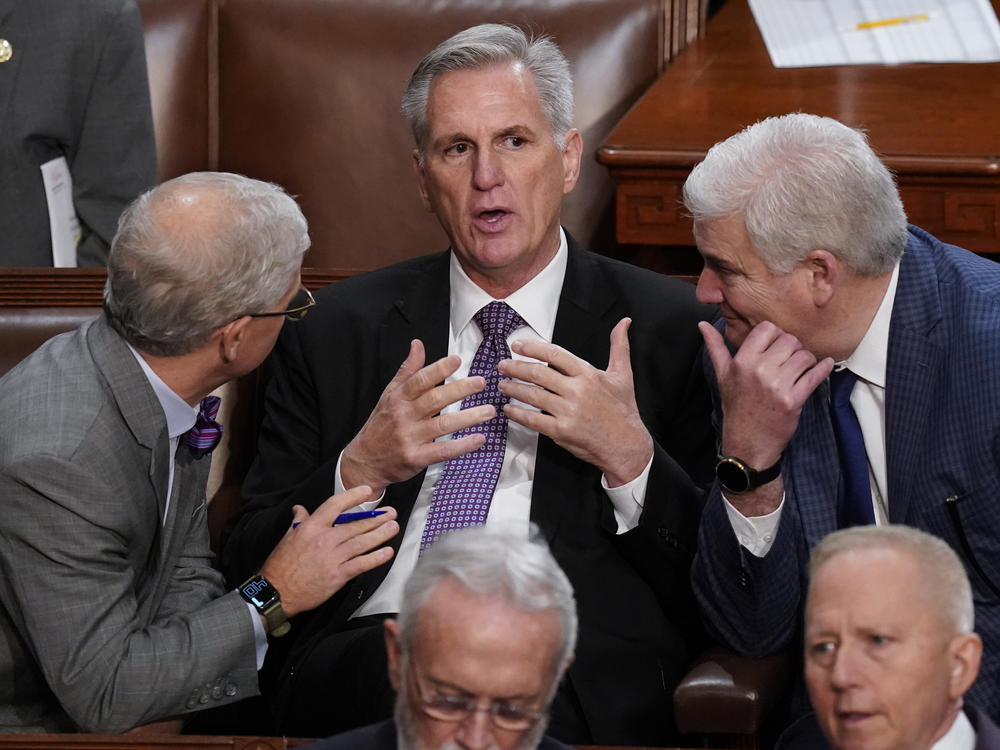 Rep. Kevin McCarthy, R-Calif., is flanked by Rep. Patrick McHenry, R-N.C., left, and Rep. Tom Emmer, R-Minn., right, in the House chamber as lawmakers meet for a second day to elect a speaker and convene the 118th Congress.