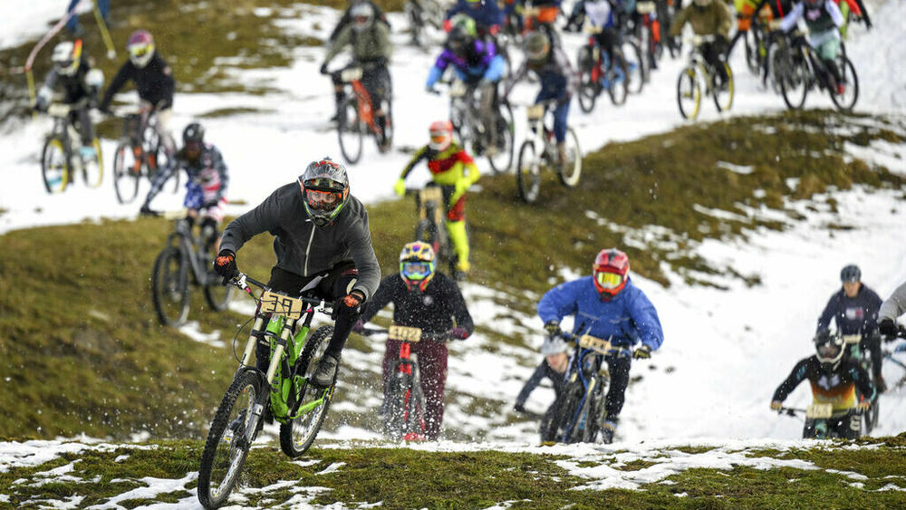 200 cyclists, some dressed in costumes, ride their bikes Saturday on the ski slopes during the start of the 33rd edition of the 'GP St-Sylvestre', a new-year snow mountain bike race, in the alpine resort of Villars-sur-Ollon, Switzerland.