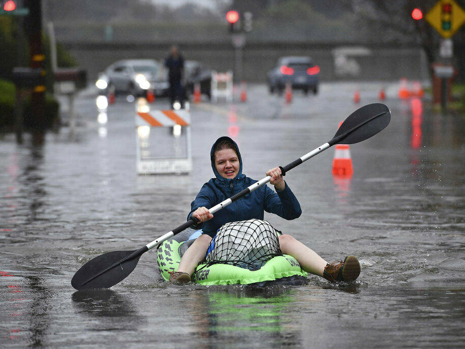 Nurse Katie Leonard uses a kayak to bring supplies to Patsy Costello, 88, as she sits trapped in her vehicle Dec. 31 on Astrid Drive in Pleasant Hill, Calif.. Costello drove her car on the flooded street thinking she could make it, but it stalled in the two feet of water.
