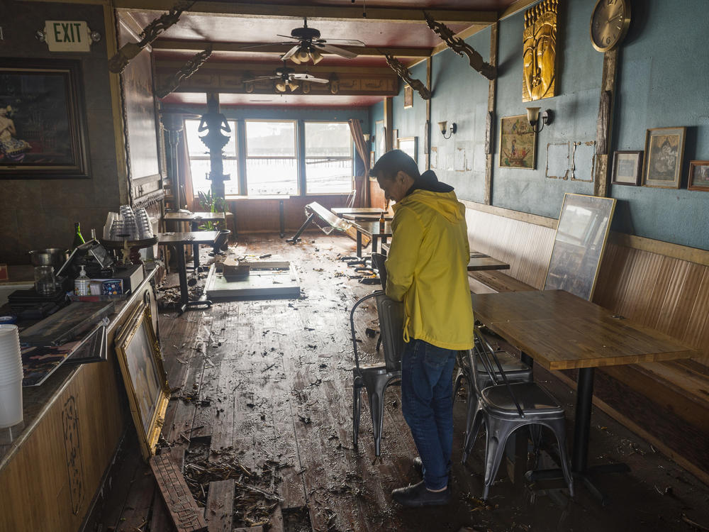 Dominic King, owner of My Thai Beach, surveys storm damage in his restaurant in Capitola, California.