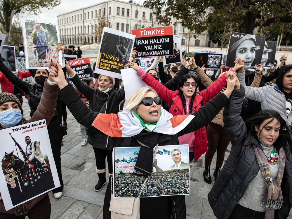 Protesters hold placards with messages such as 