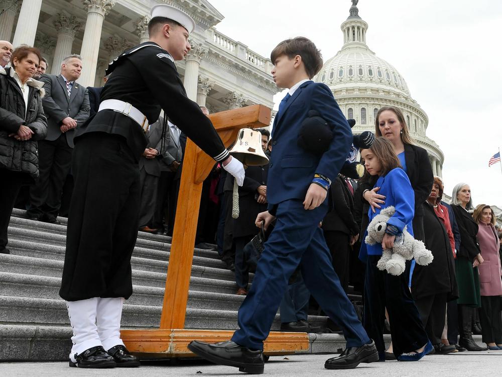 Shannon Terranova, widow of Capitol Police Officer Police Williams Evans, and their children Logan and Abigail, join a bipartisan group of lawmakers on the east front steps of the U.S. Capitol to honor the police officers who lost their lives in the attack on the Capitol, on the second anniversary of the Jan. 6 riot.