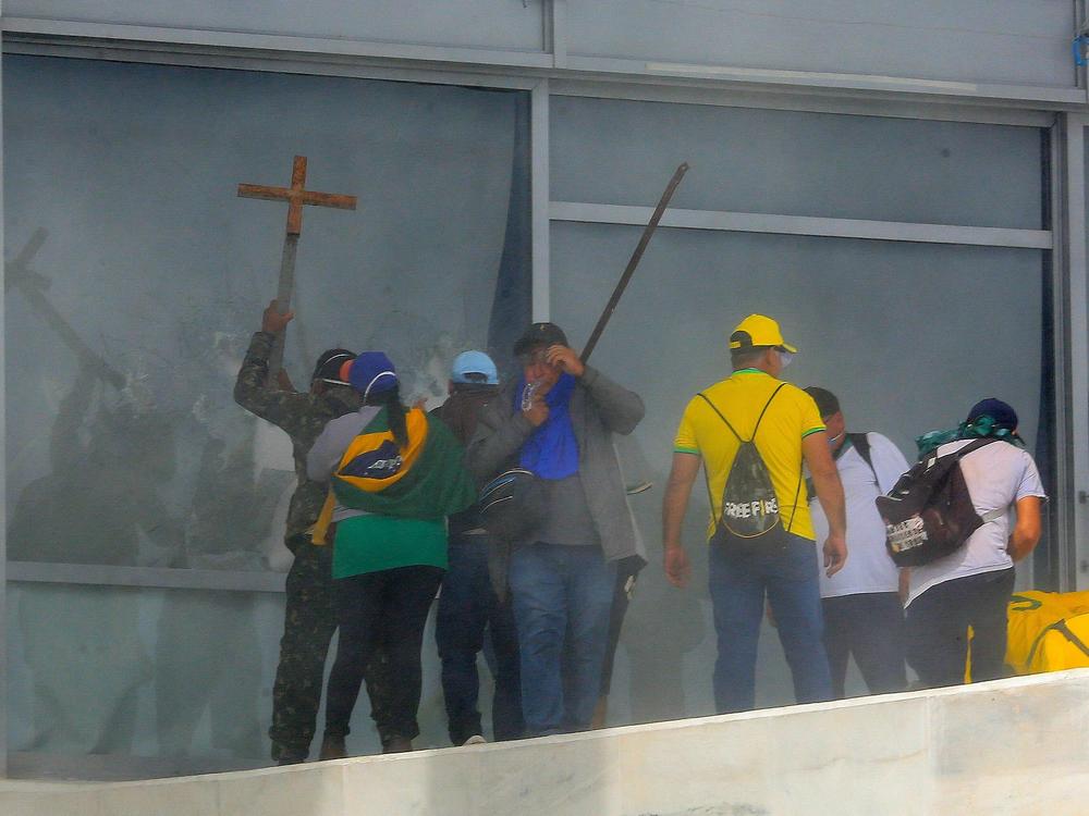 Supporters of Brazilian former President Jair Bolsonaro break a window as they invade Planalto Presidential Palace in Brasilia on Sunday.