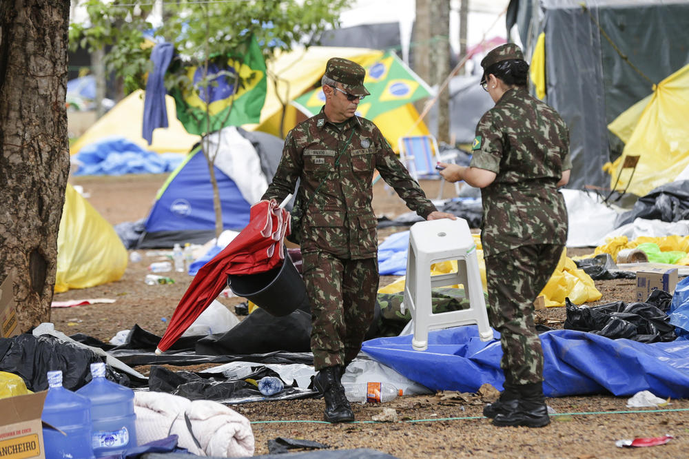Soldiers help clear out an encampment set up by supporters of former Brazilian President Jair Bolsonaro outside army headquarters in Brasília on Monday, the day after Bolsonaro supporters stormed government buildings in Brazil's capital.