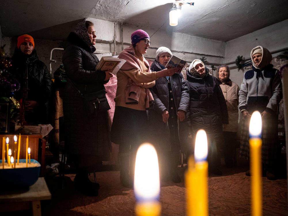 Worshipers pray during an Orthodox Christmas mass in a basement shelter in Chasiv Yar, eastern Ukraine, on Jan. 7. As artillery boomed outside and fighter jets flew overhead, Orthodox Christians in a battered eastern Ukraine town held a Christmas service in a basement shelter vowing, not to let war ruin the holiday.