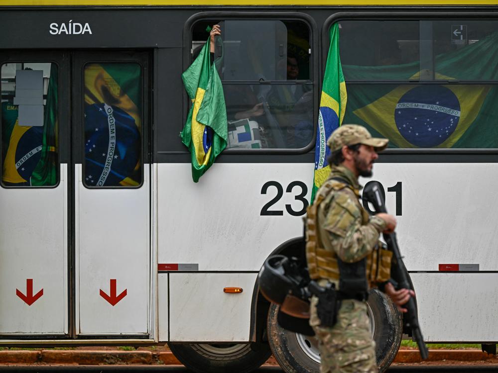 Bolsonaro supporters are taken by bus Monday to federal police headquarters. They were taken into custody after the riots at government buildings in Brasilia on Sunday.
