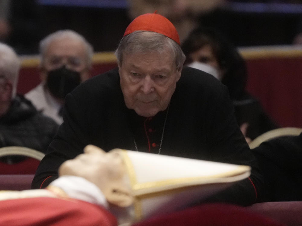 Australian Cardinal George Pell stands next to the body of late Pope Emeritus Benedict XVI lied out in state inside St. Peter's Basilica at The Vatican on Jan. 3.