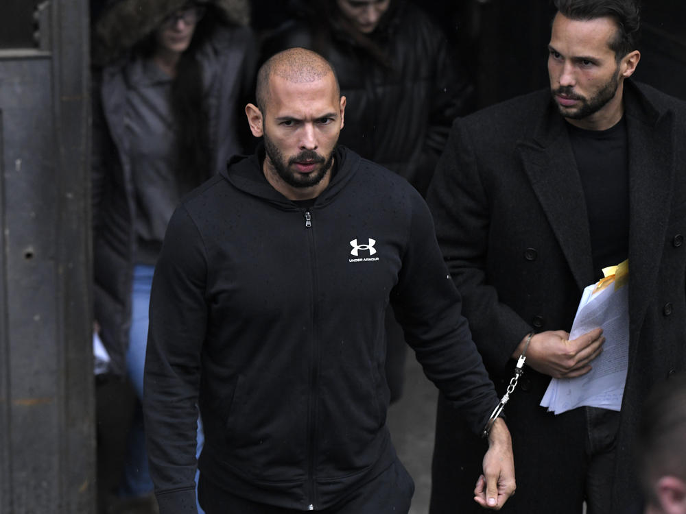 Andrew Tate (center) and his brother Tristan leave after appearing at the Court of Appeal, in Bucharest, Romania, on Tuesday.