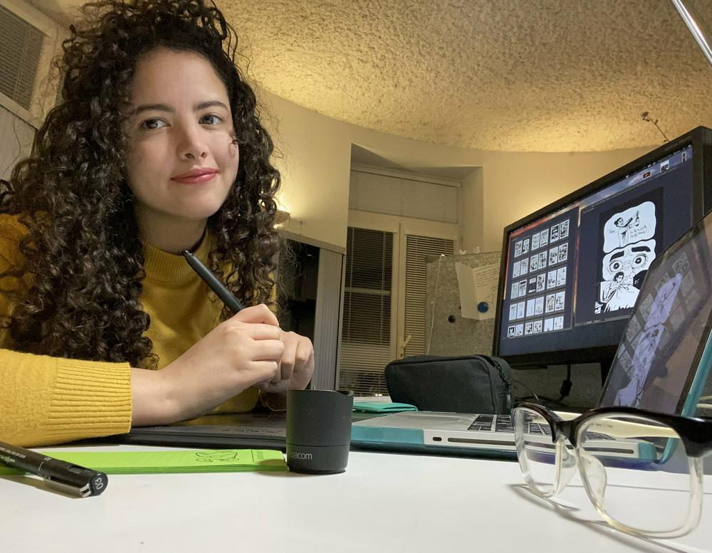 Deena Mohamed drawing at her desk. She started working on the graphic novel <em>Shubeik Lubeik</em> while she was a graphic design student at the American University in Cairo. The book was published in English this week.