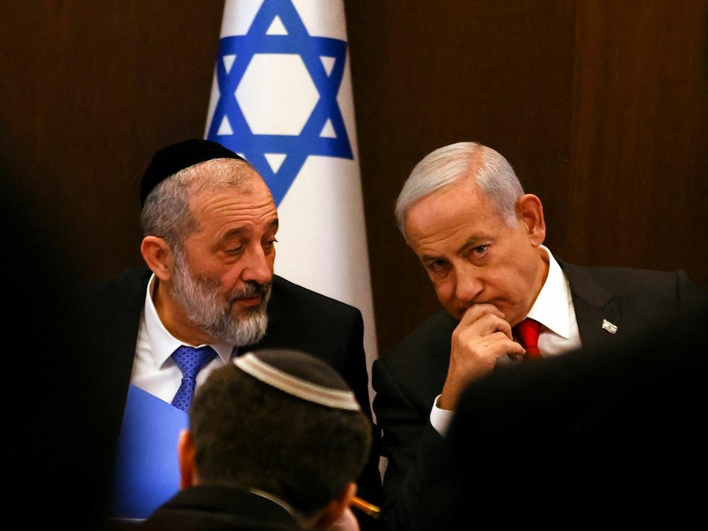Israel's Prime Minister Benjamin Netanyahu (right) sits next to Interior and Health Minister Aryeh Deri during a weekly cabinet meeting on Jan. 8, 2023.