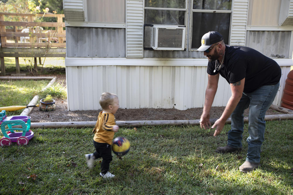 Brandon Cunningham, with his youngest son, has a good-paying job now and watches his savings grow. 