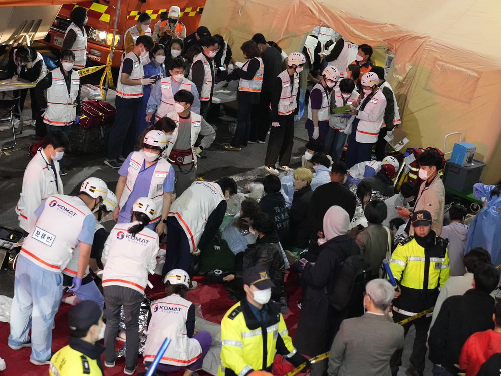 Rescue workers treat injured people on the street near the scene of a crowd surge in Seoul, South Korea, on Oct. 30, 2022. South Korean police on Friday, Jan. 13, 2023, said they are seeking charges of involuntary manslaughter and negligence against 23 officials.