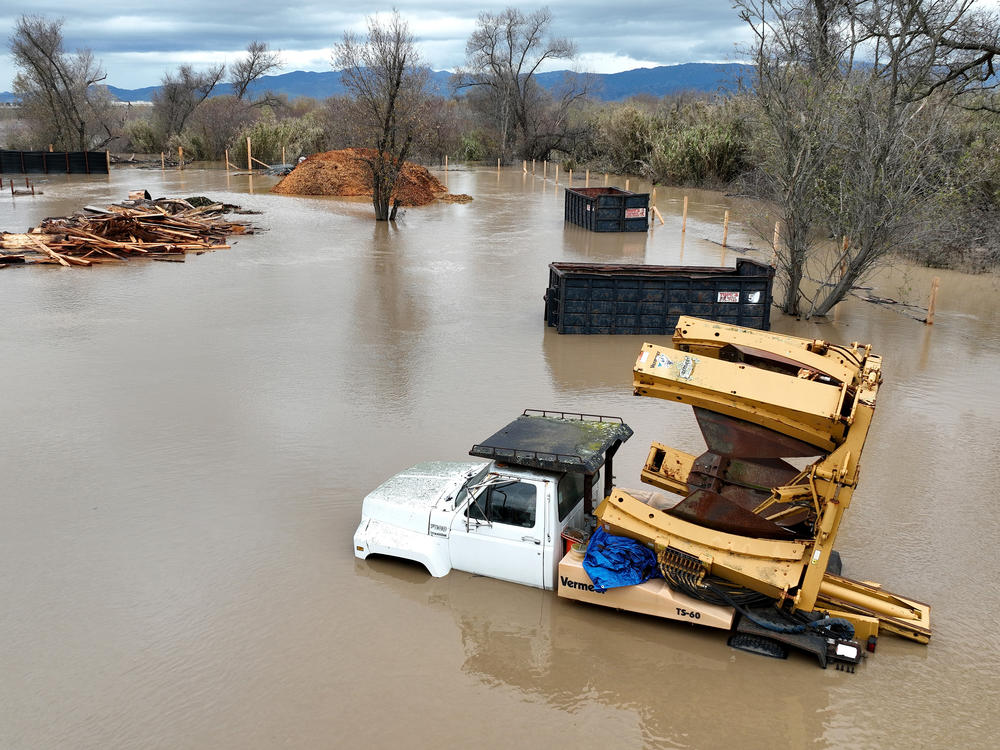 In an aerial view, farming equipment is seen submerged in floodwater after the Salinas River overflowed its banks on Friday in Salinas, Calif.