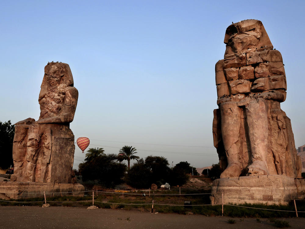 The Colossi of Memnon, two sandstone statues of Amenhotep III, are seen in Luxor in 2017. Excavators say they have discovered a new ancient tomb in the Egyptian city.