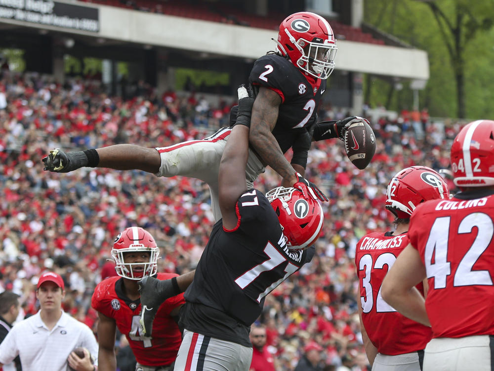 University of Georgia running back Kendall Milton, #2, celebrates after a touchdown with offensive lineman Devin Willock, #77, during the school's spring NCAA college football game on Saturday, April 16, 2022, in Athens.