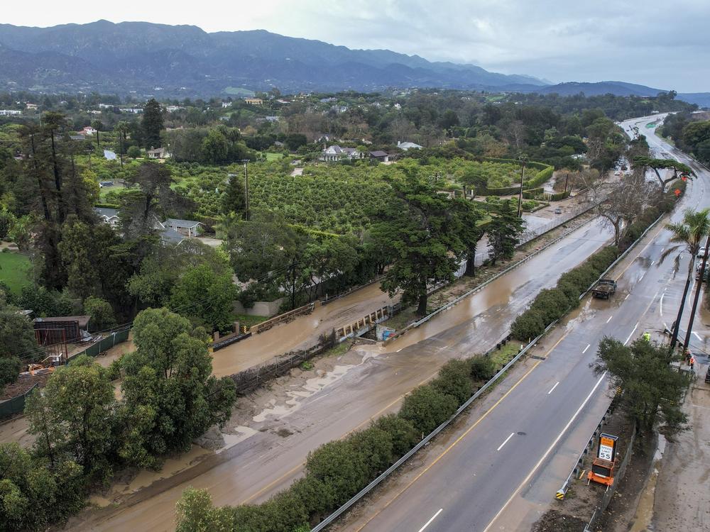Water floods part of a road by the San Ysidro creek on Jameson Lane near the closed Highway 101 in Montecito, Calif., Jan. 10, 2023. Relentless storms from a series of atmospheric rivers have saturated the mountains and hillsides scarred from wildfires along much of California's coastline.