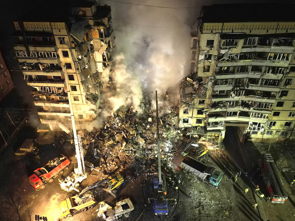 Emergency workers clear the rubble after a Russian rocket hit a multistory building leaving many people under debris in the southeastern city of Dnipro, Ukraine, on Jan. 14, 2023.