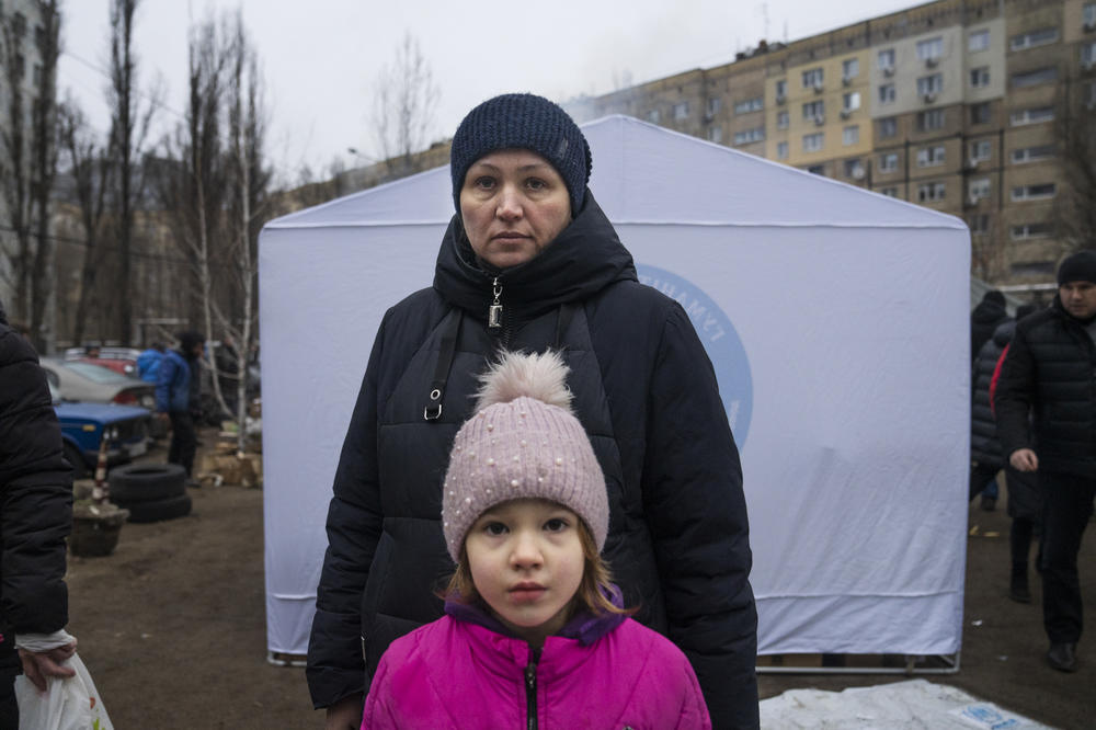 Larysa Shevchenko and her 6 year-old daughter, Kateryna, stand outside near relief stations. The family lived in the building and at the time of the attack, Larysa remembers looking out the window and seeing a fireball.