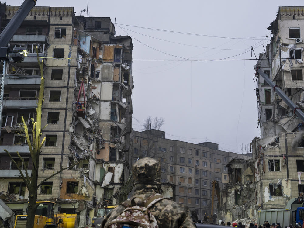 A soldier stares up at a gaping hole in an apartment building in Dnipro, Ukraine on Monday. The city was hit by Russian missiles on Saturday.