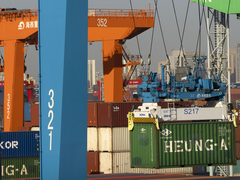 A crane lifts a shipping container at a container port in Tianjin, China, Monday, Jan. 16, 2023. China's economic growth fell to 3% last year under pressure from antivirus controls and a real estate slump.