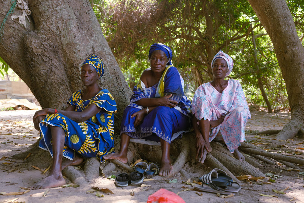 Women gather at the entrance to a sacred forest on Feb. 24, 2021, in Casamance, Senegal, where residents come for medical treatments.