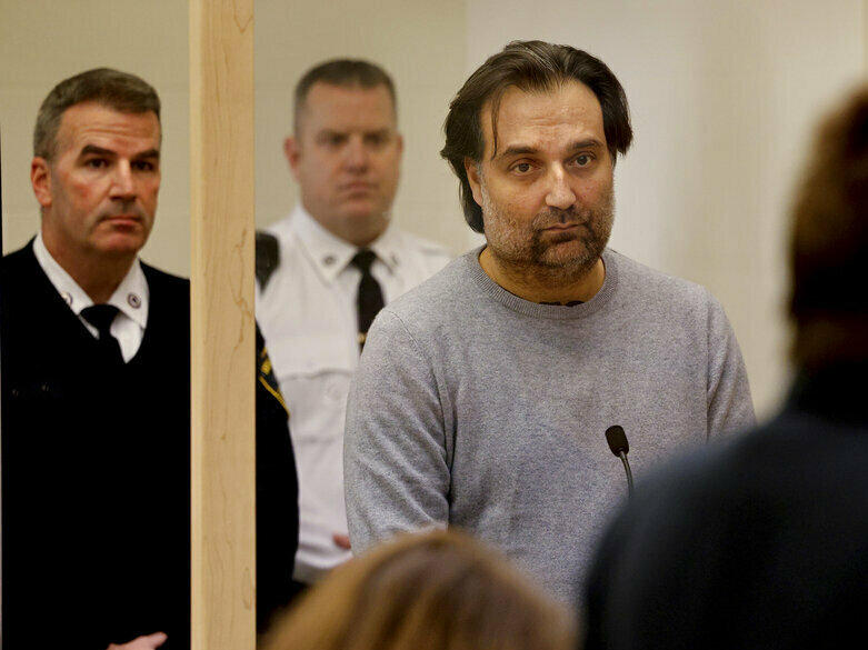 Brian Walshe, center, listens during his arraignment Wednesday at Quincy District Court, in Quincy, Mass., on a charge of murdering his wife Ana Walshe.