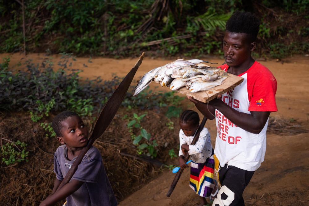 The residents of Barconie, Liberia, fish from the ocean on Nov. 16, 2022. A sacred lagoon close to the town is off-limits from being exploited.