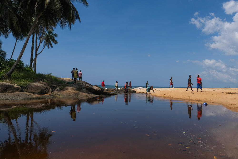 Residents of Barconie stand over their sacred lagoon after a ceremony on Nov. 16, 2022.