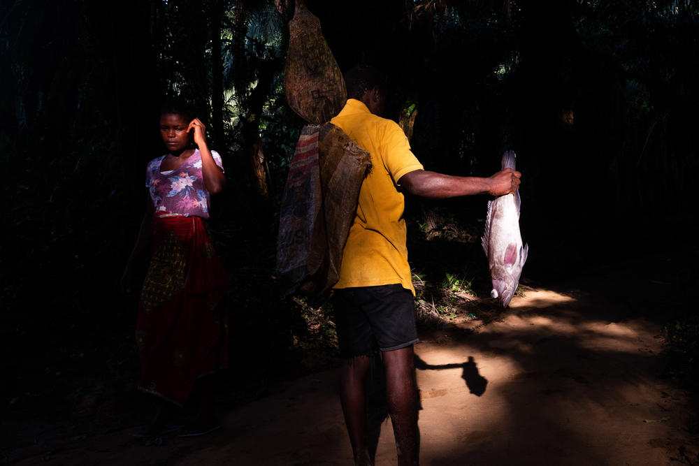 The residents of Barconie, Liberia, fish from nearby ocean on Nov. 16, 2022. A sacred lagoon close to the town is off-limits from being exploited.