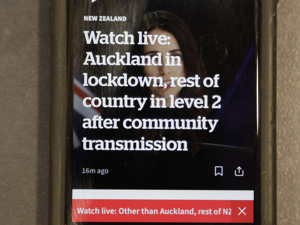 A news alert is displayed on a mobile phone in Christchurch, New Zealand, Tuesday, Aug. 11, 2020.