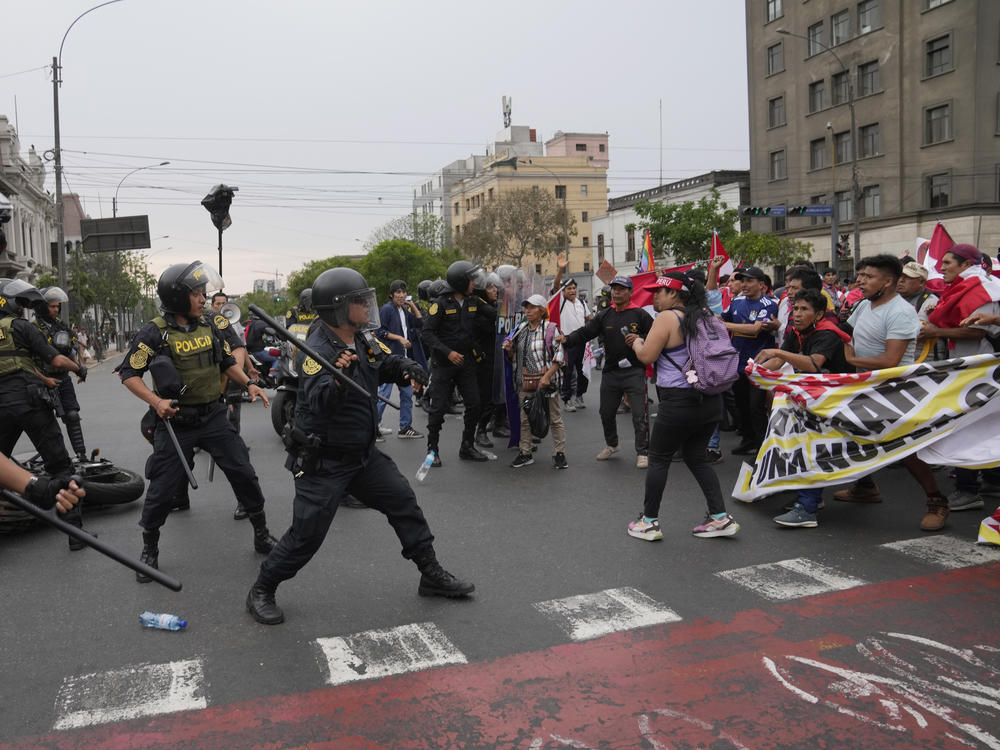 Anti-government protesters who traveled to the capital from across the country march against Peruvian President Dina Boluarte clash with the police in Lima, Peru,  on Wednesday. Protesters are seeking immediate elections, Boluarte's resignation, the release of ousted President Pedro Castillo and justice for the dozens of protesters killed in clashes with police.