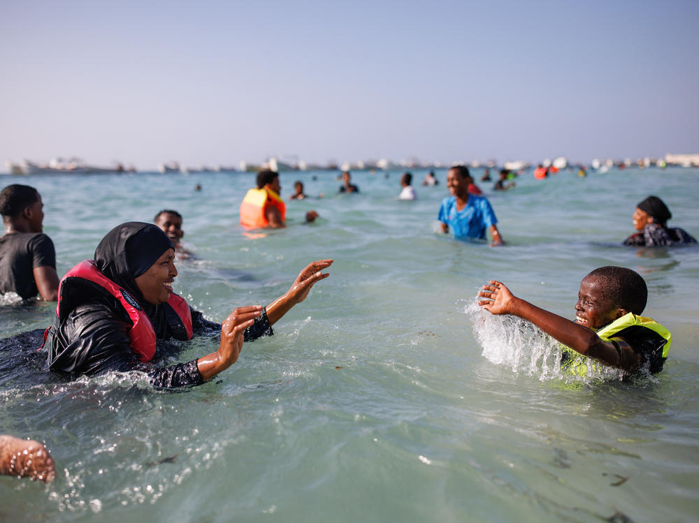 A mother and her son play in the sea at Liido Beach in Mogadishu, Somalia. Despite decades of conflict and ongoing security threats, some Somalis are carving out a middle-class lifestyle in the Somali capital.