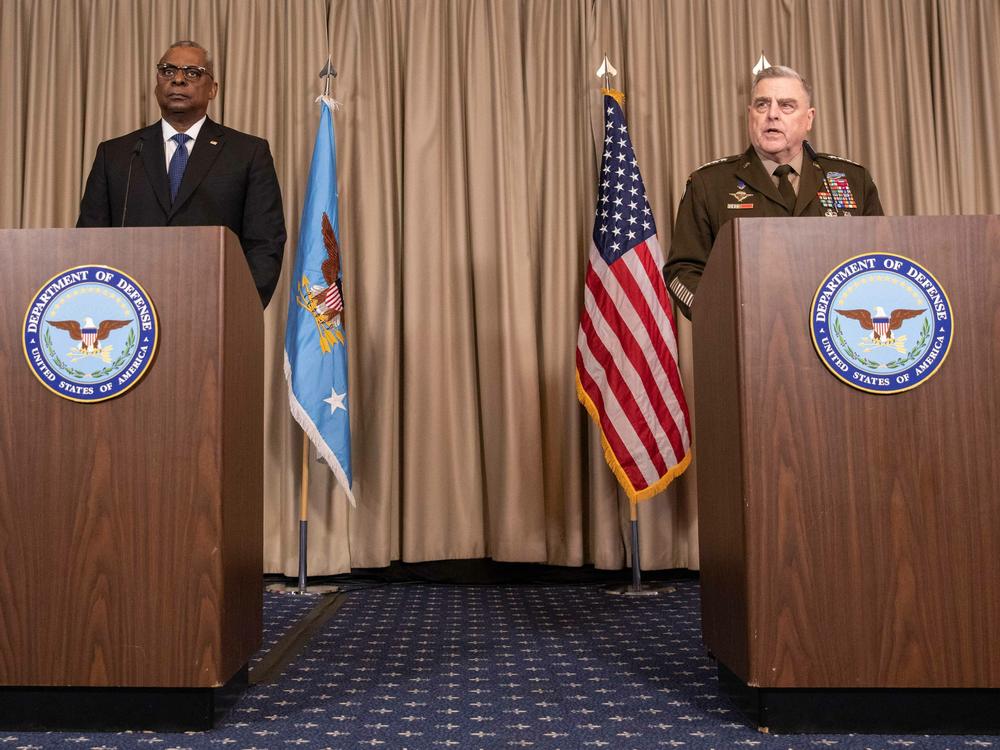 U.S. Defense Secretary Lloyd Austin (left) and the chairman of the Joint Chiefs of Staff, Gen. Mark Milley, discuss details of a huge U.S. and NATO arms package for Ukraine at the U.S. air base in Ramstein, Germany, on Friday.