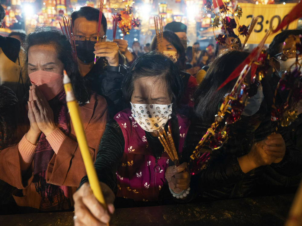 Worshippers wearing face masks burn their first joss sticks as they pray at the Wong Tai Sin Temple in Hong Kong, Saturday, Jan. 21, 2023, to celebrate the Lunar New Year which marks the Year of the Rabbit in the Chinese zodiac.