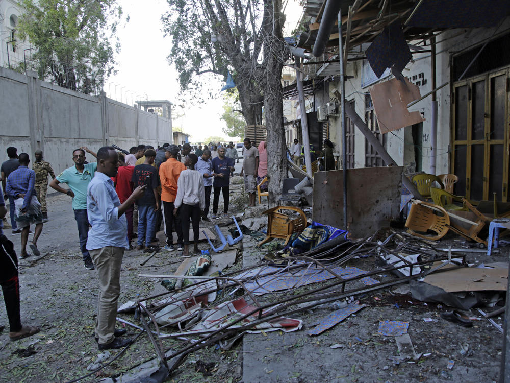 People gather outside their destroyed shops after a suicide bomber detonated at the Banadir regional administration in Mogadishu on Sunday.